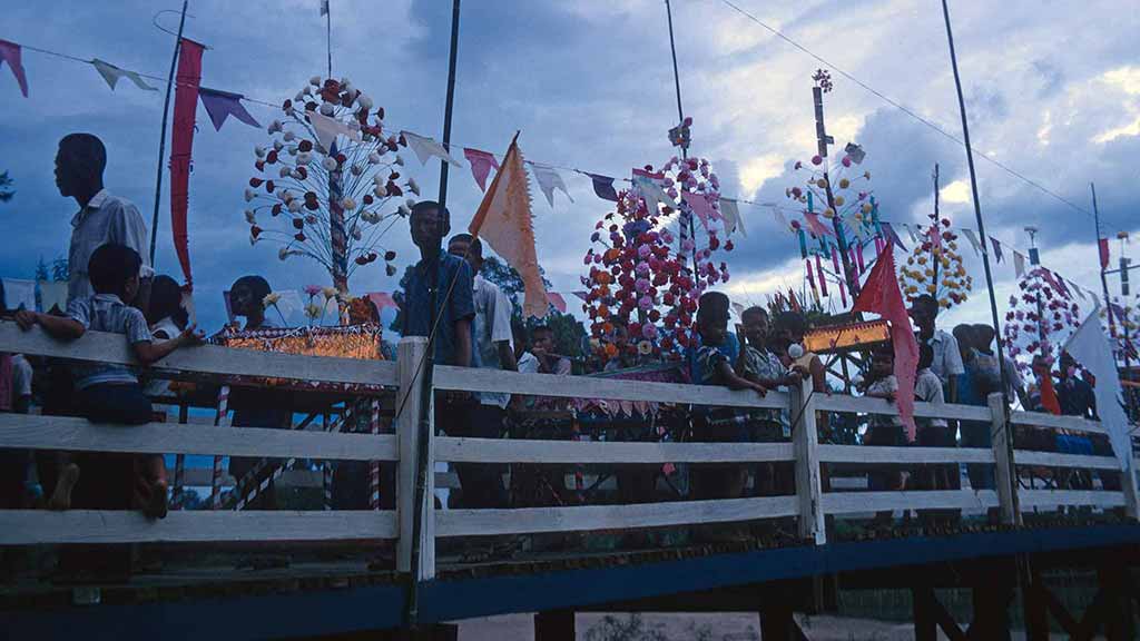 people carry decorations across a bridge