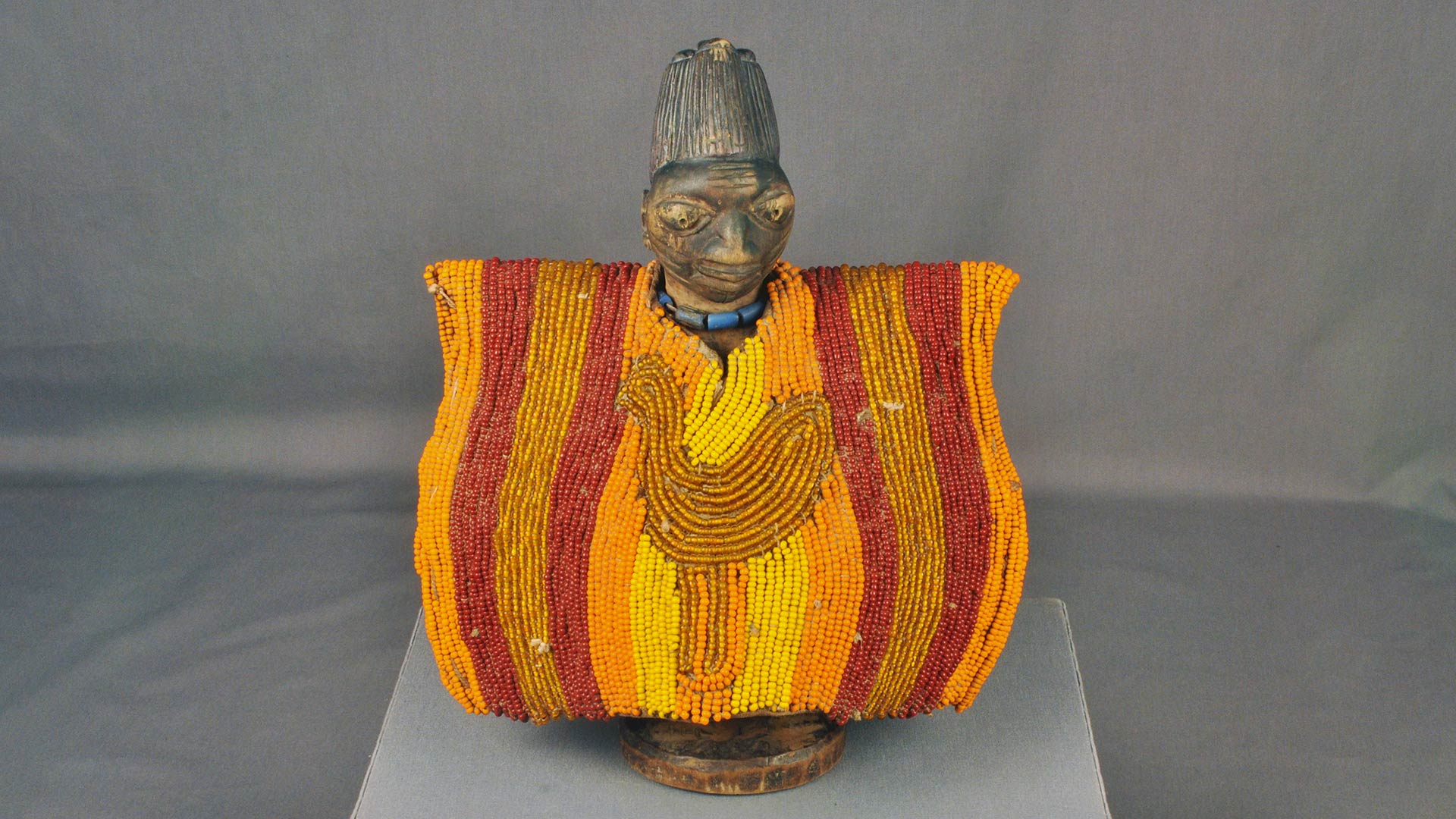 wooden figure with orange and yellow beaded coat