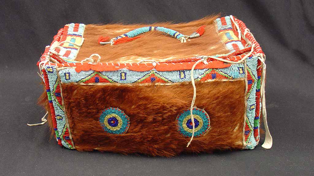 box-shaped bag with handle covered in animal fur and beads