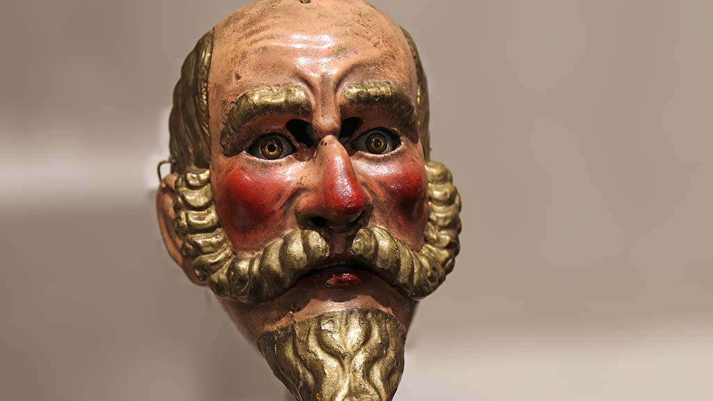 lifelike human mask with rosy cheeks and a long mustache and beard